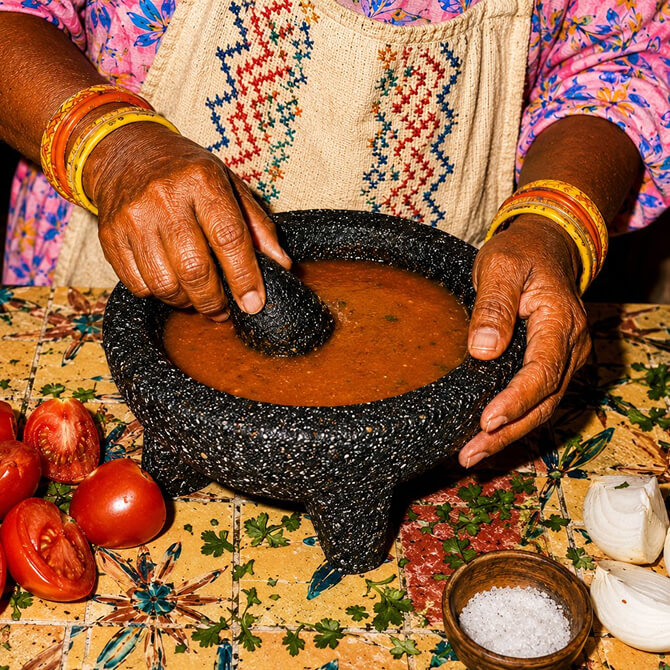 Marta cooking up some Marta's Roasted Tomato Salsa using fresh ingredients